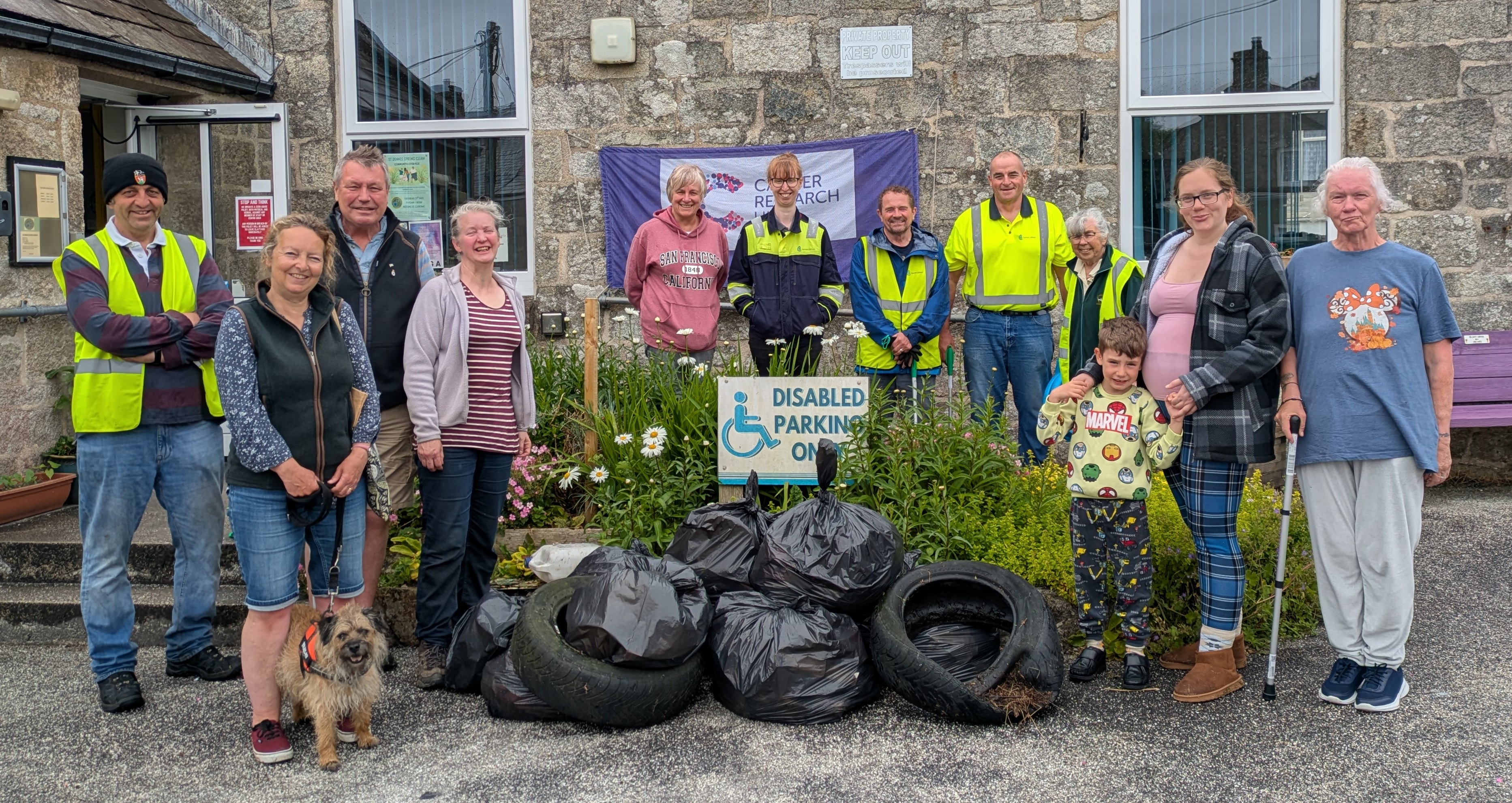 A group of Councillors and residents stand next to a pile of black bags in front of the ClayTAWC building